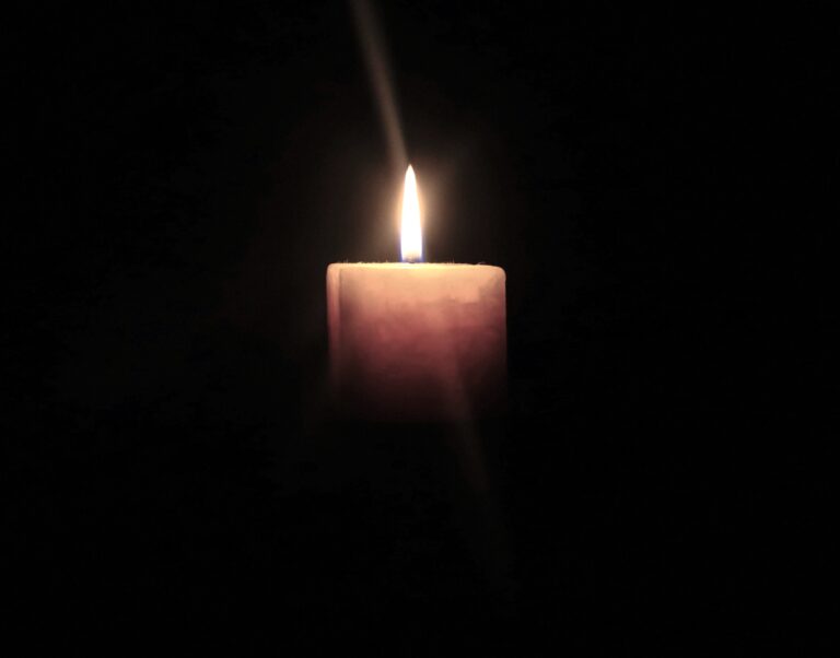 Intense Sorrow symbolised by a single candle in darkness, reflecting prolonged, unspoken grief and emotional weight.