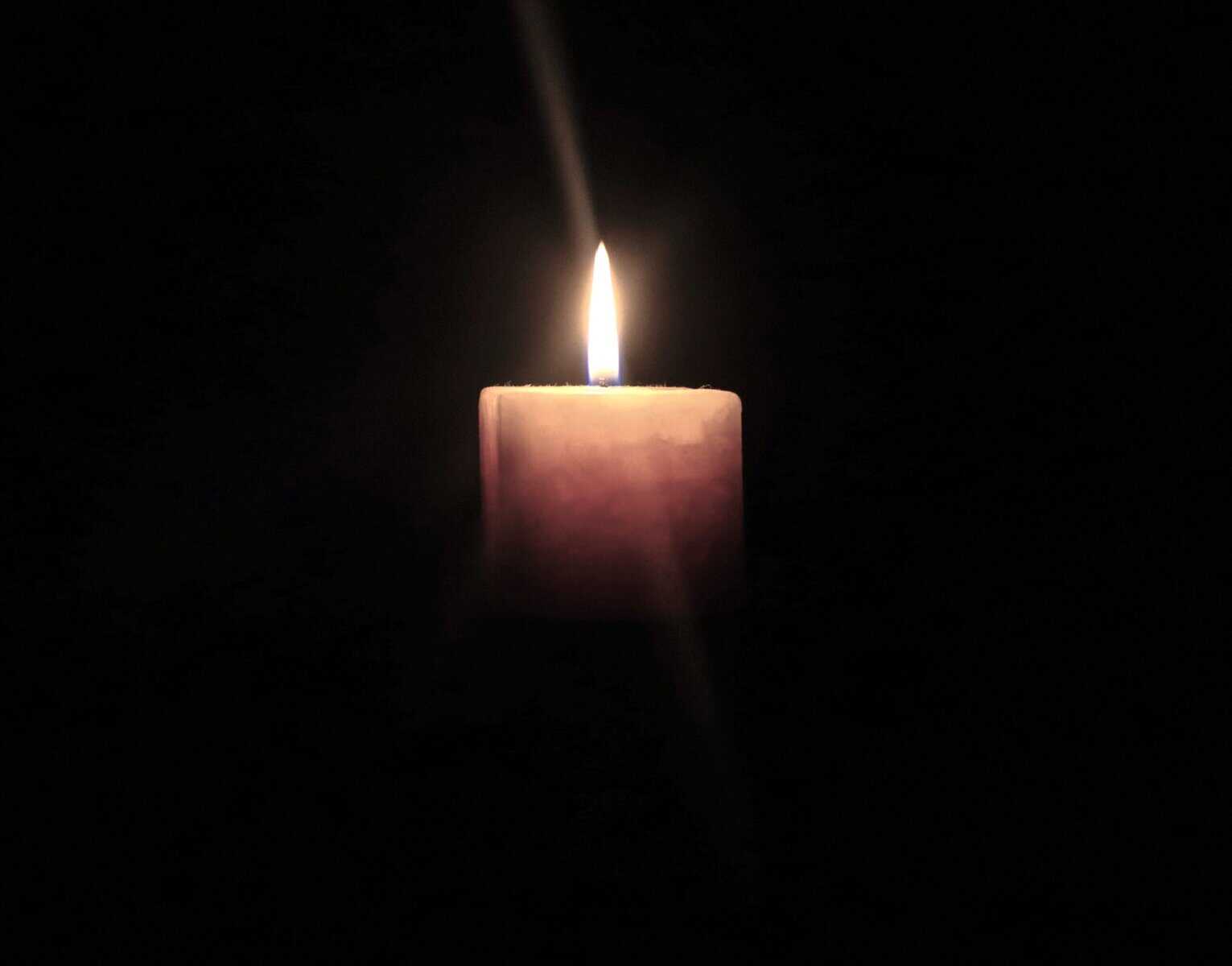 Intense Sorrow symbolised by a single candle in darkness, reflecting prolonged, unspoken grief and emotional weight.