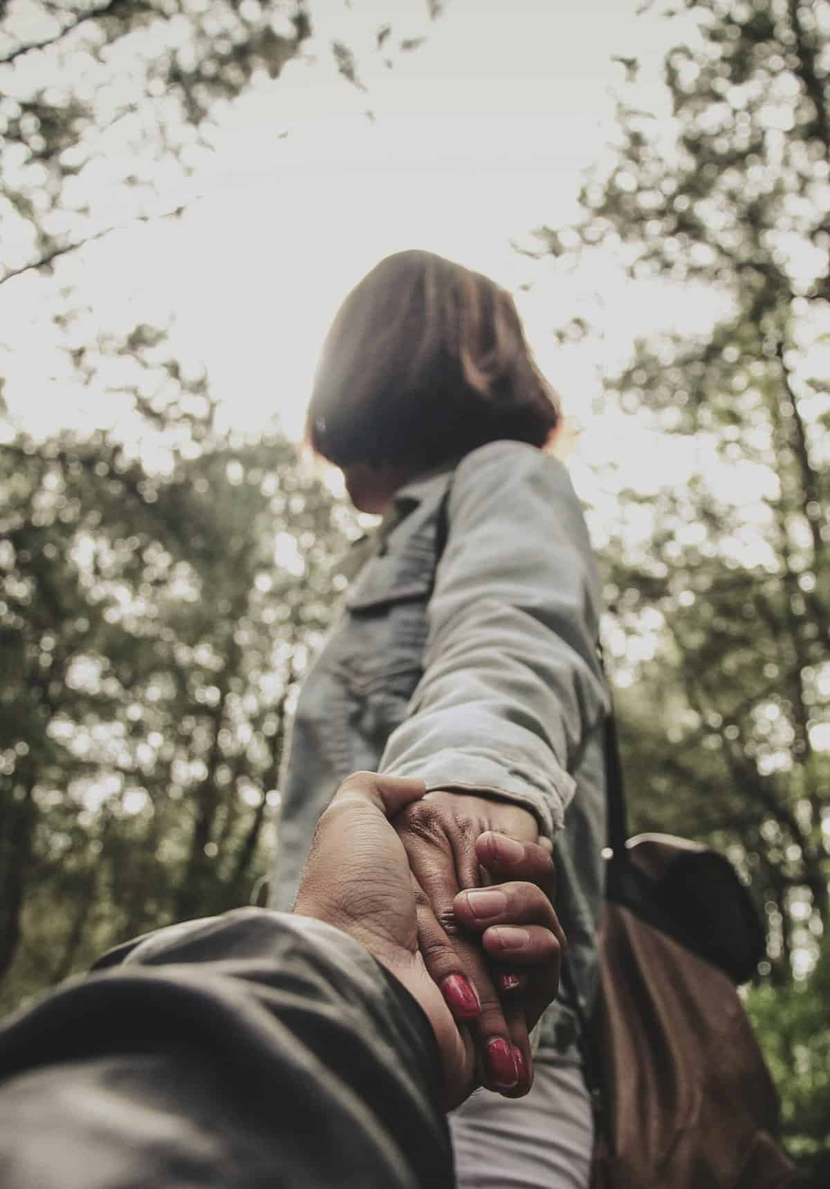 A couple holding hands outdoors symbolising Zero Notification Nights and commitment to transformative digital-free connection together.