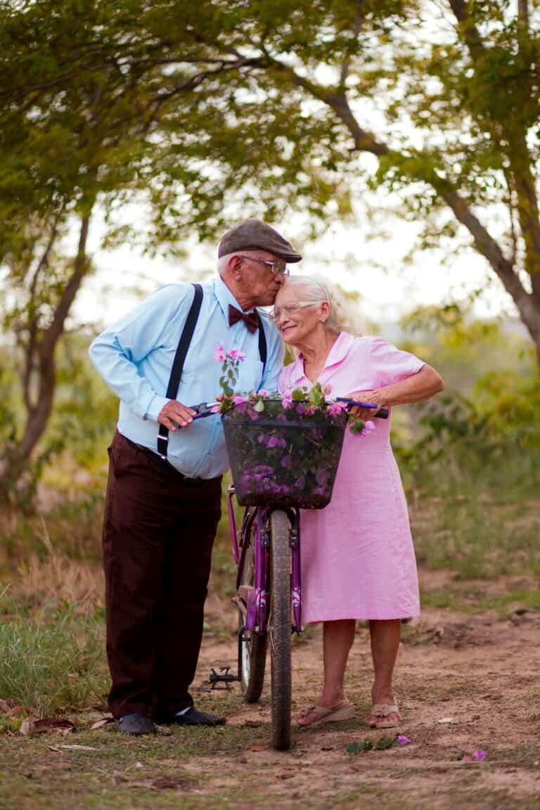 Elderly couple enjoying a tender moment by bike, representing wellness despite Senior Health Medication Risks.