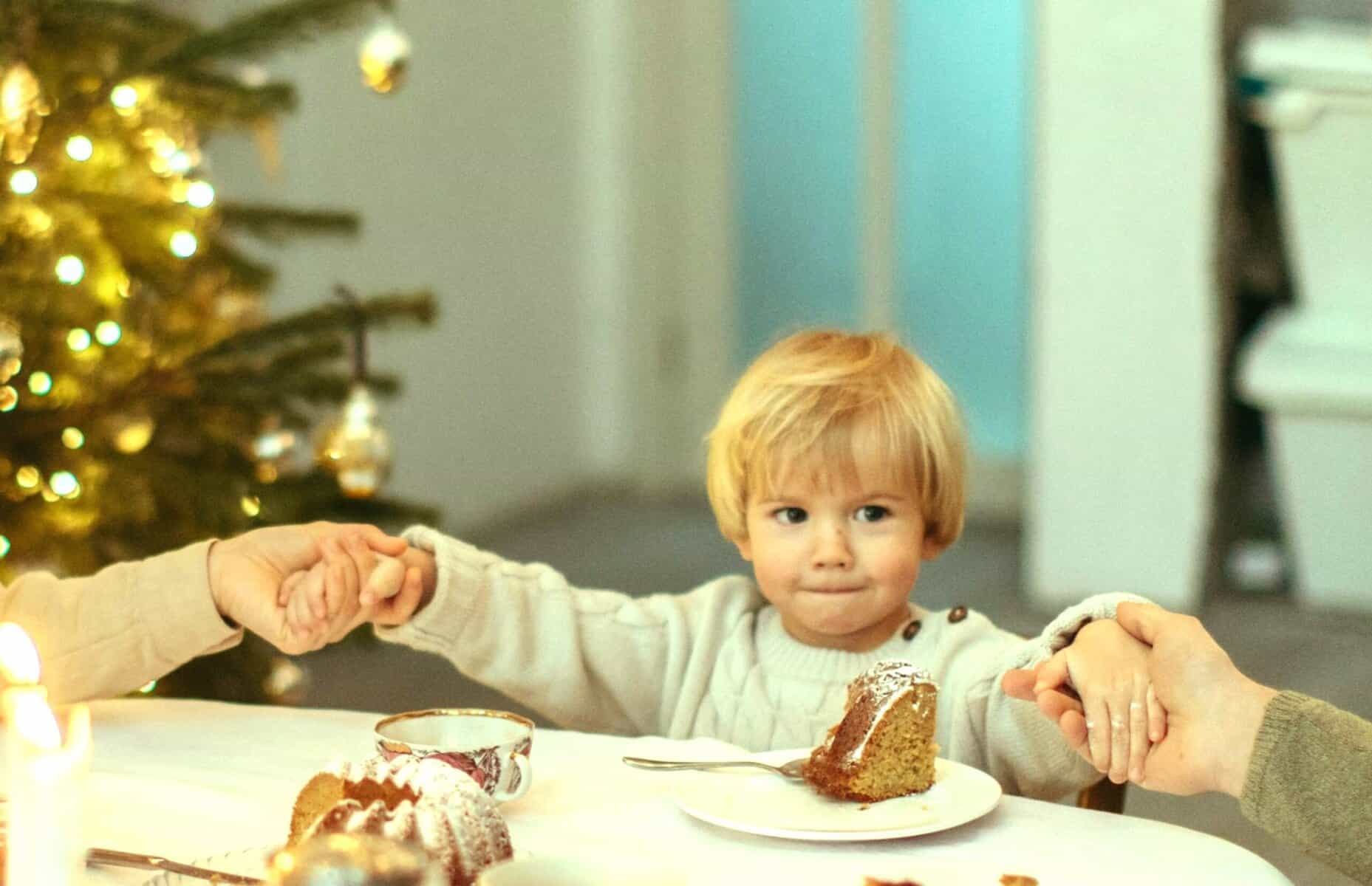 A child shares a warm Christmas meal with loved ones, symbolising Brighter Holiday Experiences after family separation.