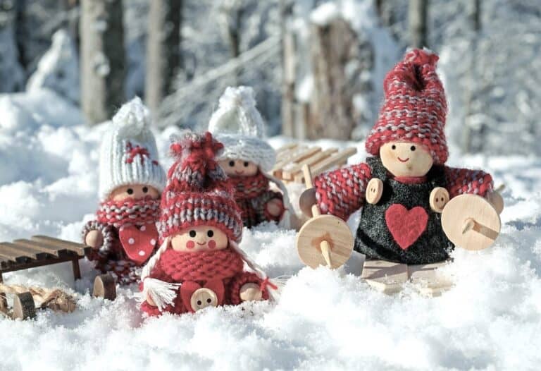 Cosy wooden dolls in the snow represent family dynamics, recovery and emotional healing after Triggering Conversations.
