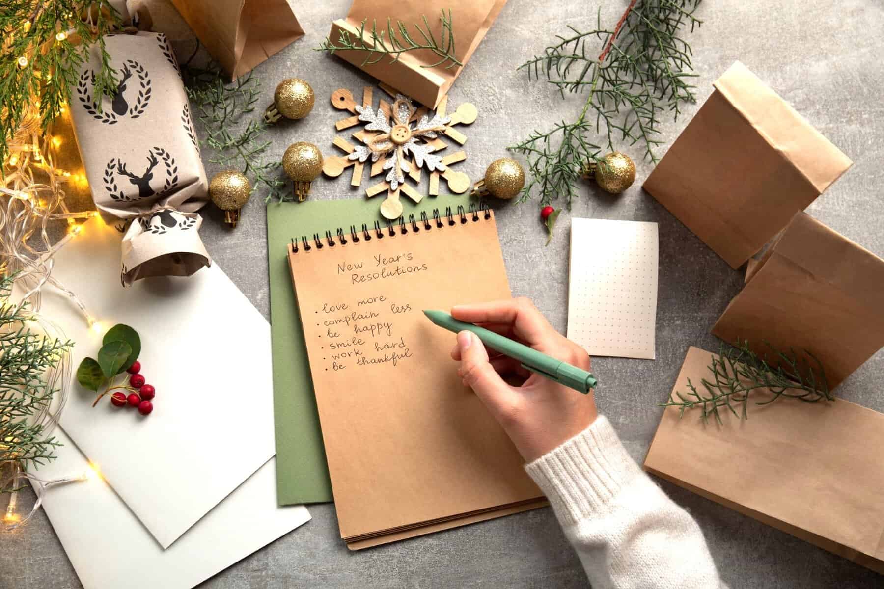 A person writing mental health goals on a New Year checklist to reflect and Build Emotional Resilience.