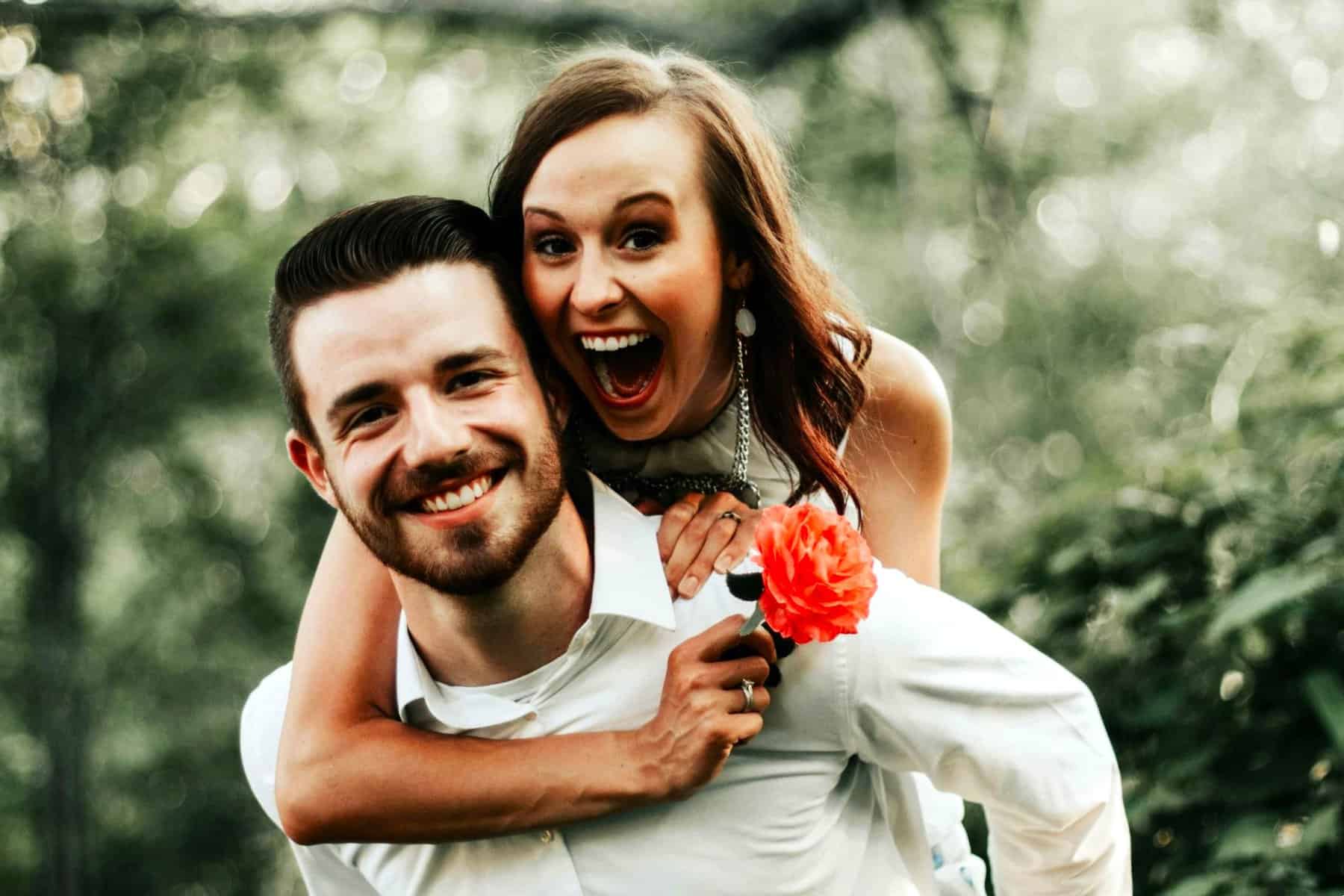 Couple smiling and embracing outdoors, expressing emotional connection and Healthy Relationship Signs.