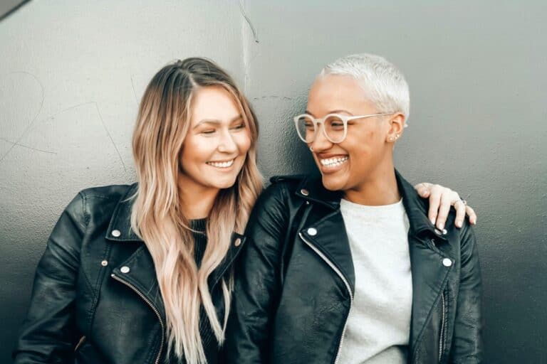 Two women smiling and connecting with trust, support, and growth through Assertive Communication.