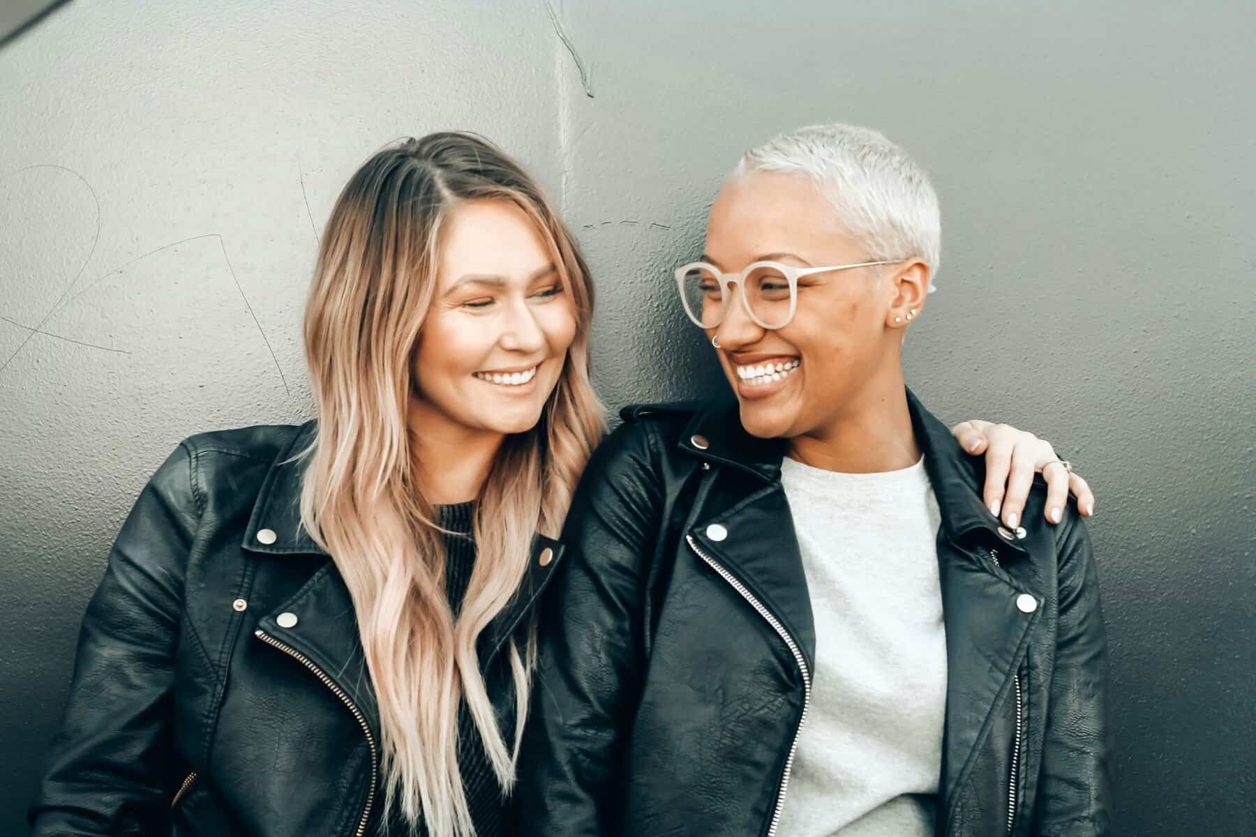 Two women smiling and connecting with trust, support, and growth through Assertive Communication.