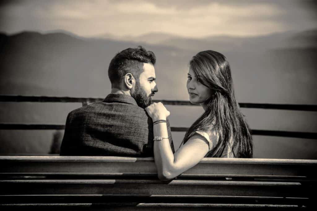 Couple seated apart in silence symbolising growing distance and early signs of Neglect In Romantic Relationships.