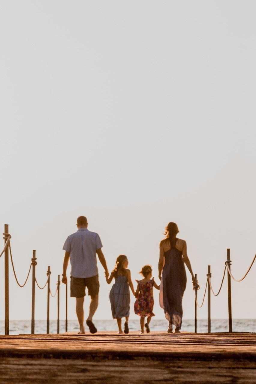 Family walking hand in hand at sunset, symbolising connection and New Year Bonding Ideas.