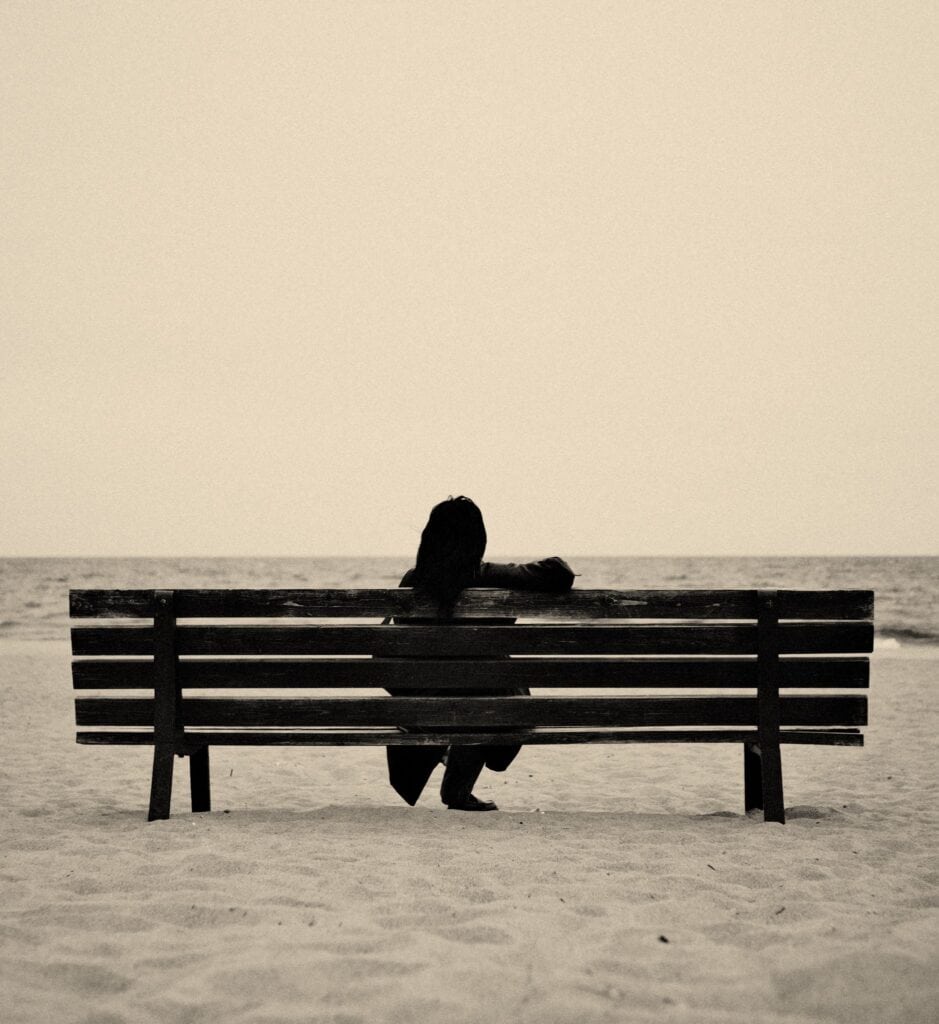 Person sitting alone after a recent breakup to mentally heal using Reconnecting Rituals For Healing.