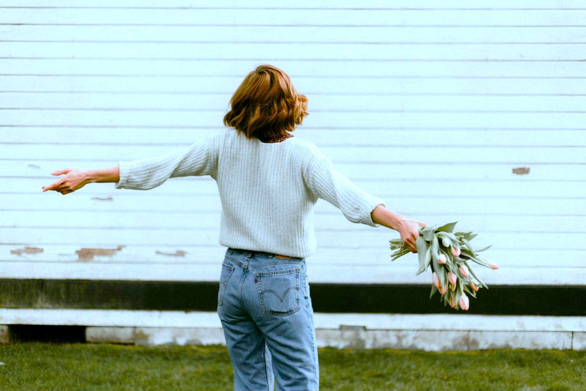 Woman holding flowers alone on Valentine's Day, it's no big deal since psychology passes a message regarding Heartfelt Compassion.