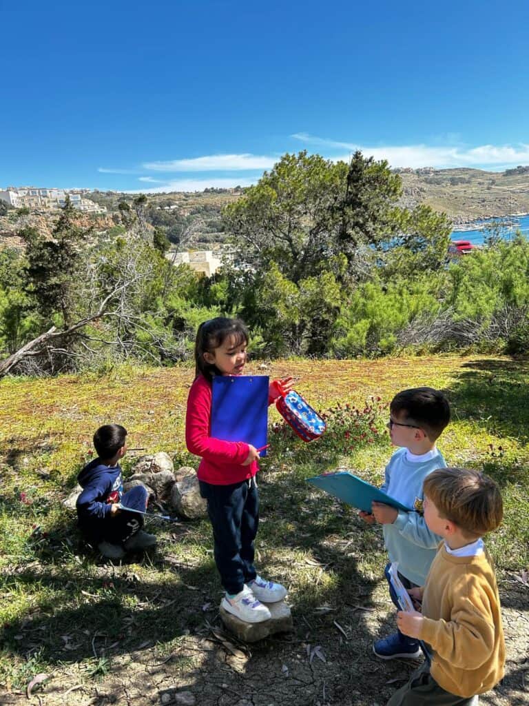 Children engaging in outdoor learning, exploring nature and practicing social skills in a natural setting.
