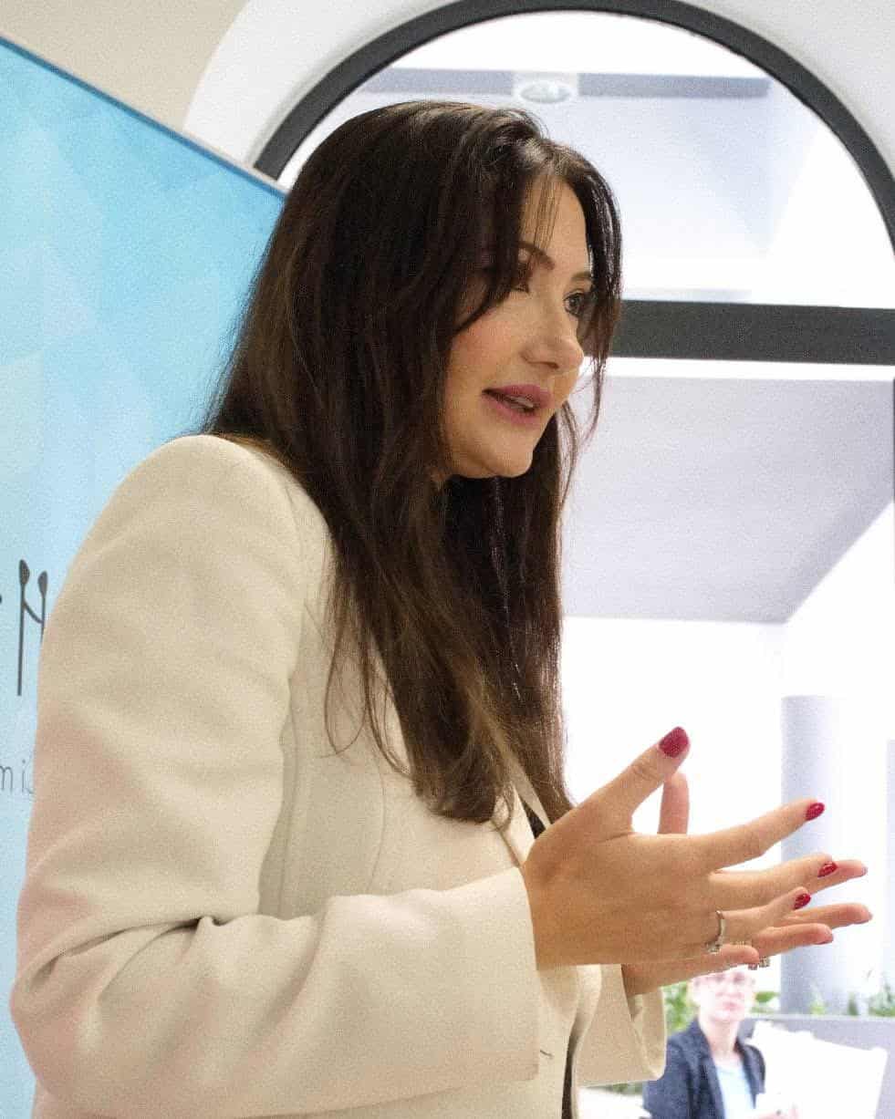 A woman leading a mental health workshop, engaging participants in a discussion about emotional openness and personal growth.
