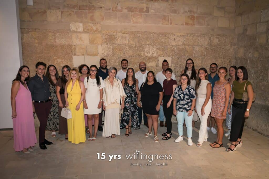 Support group photo of diverse individuals standing together in a community setting, promoting mental health, resilience, and family support.