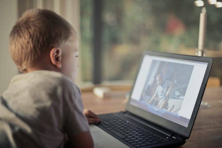 Child using laptop alone, showing screen overuse risks, social media bullying, and emotional impact due to Healthy Screen Habits Development.