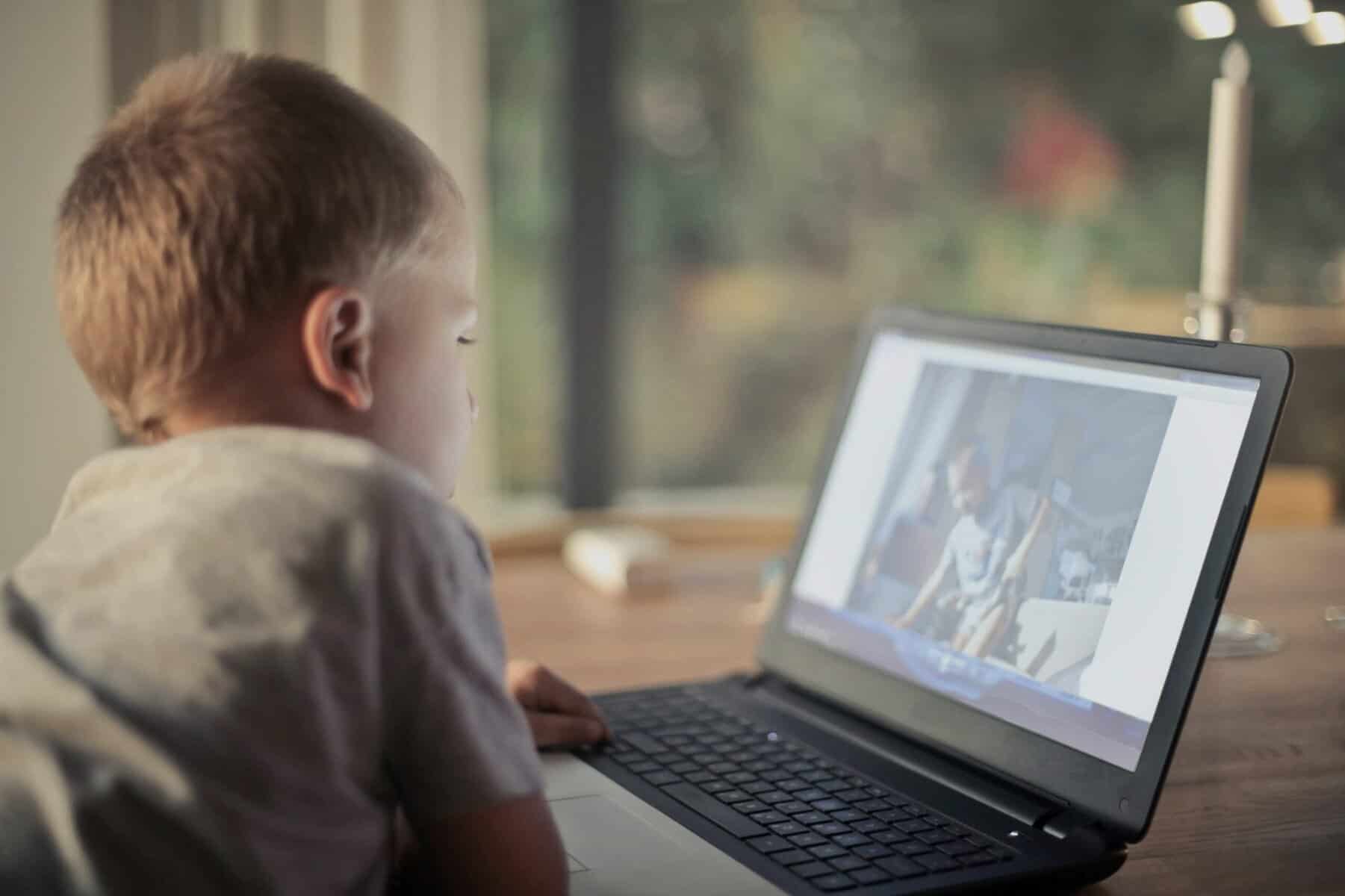 Child using laptop alone, showing screen overuse risks, social media bullying, and emotional impact due to Healthy Screen Habits Development.