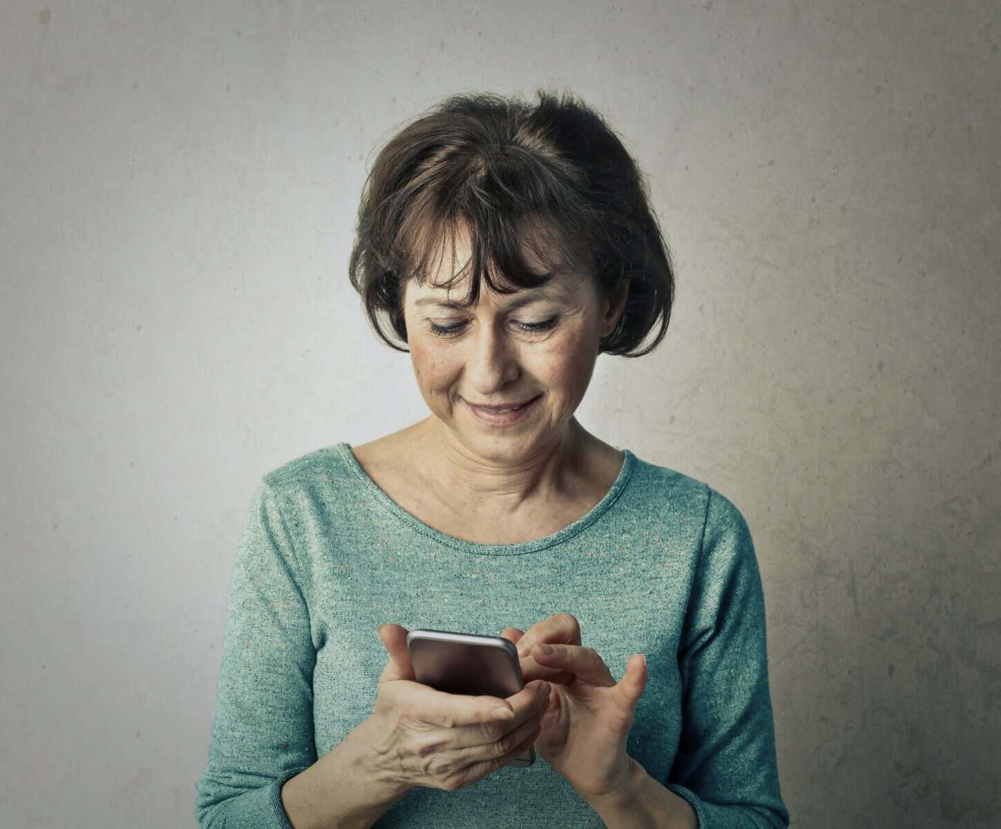Older woman learning digital technology with passionate support, reducing exclusion via Older Accessibility initiatives.