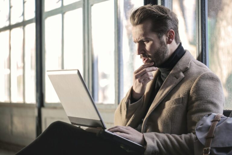 Man thinking while working at a laptop
